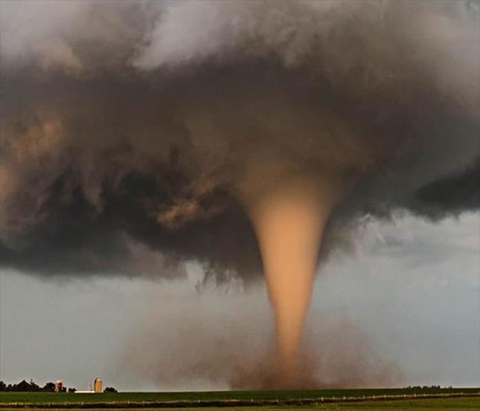 A picture of a tornado in a field.